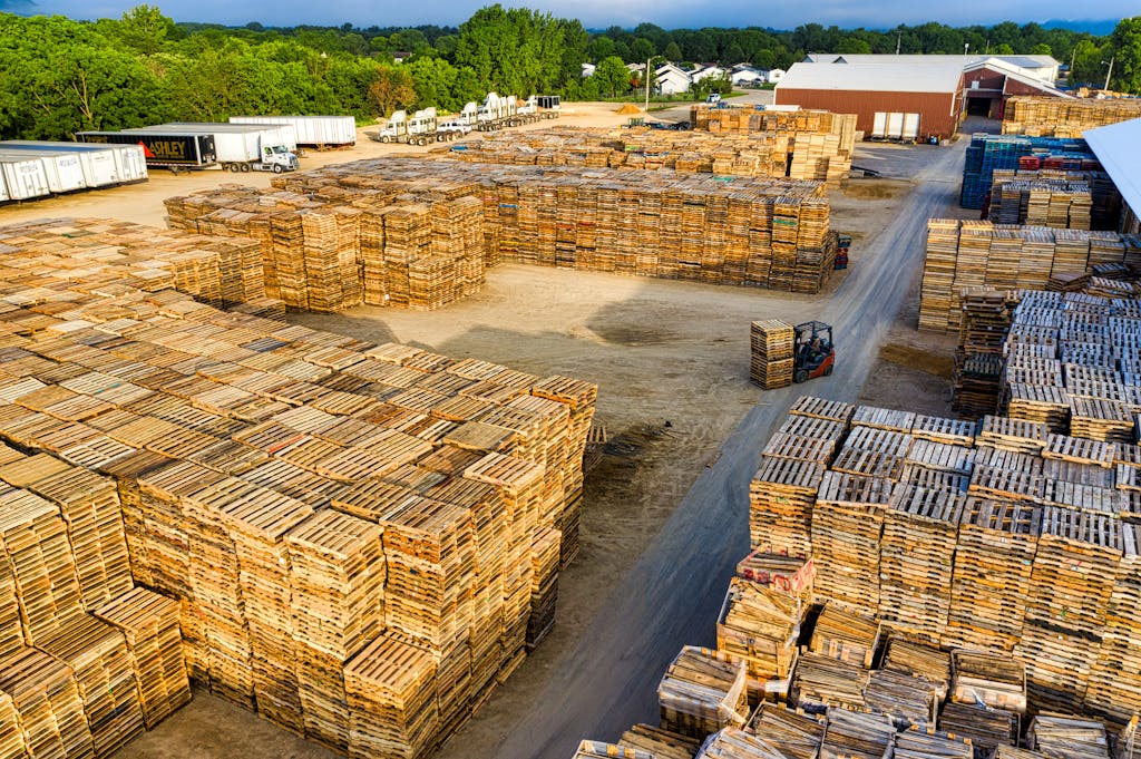 Aerial view showcasing large stacks of wooden pallets in an outdoor storage facility in Lake City, MN.