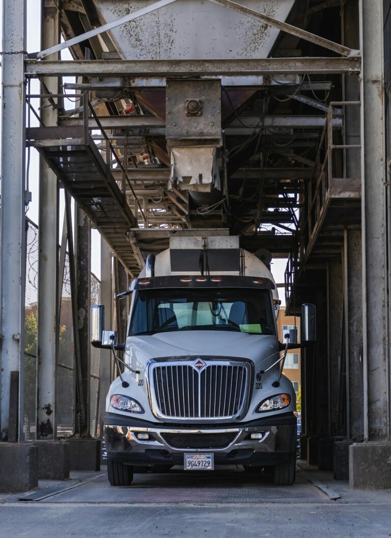 Close-up of a truck under machinery in an industrial setting.